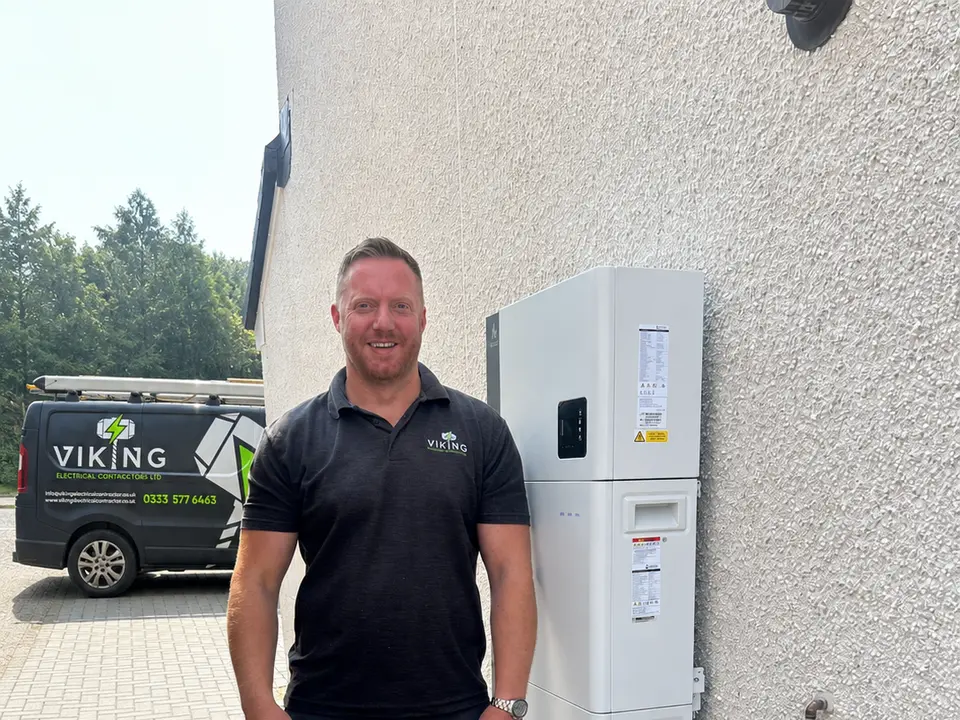 Chris Leisk, Viking sales director, standing beside an Alpha ESS home battery with a Viking van parked behind