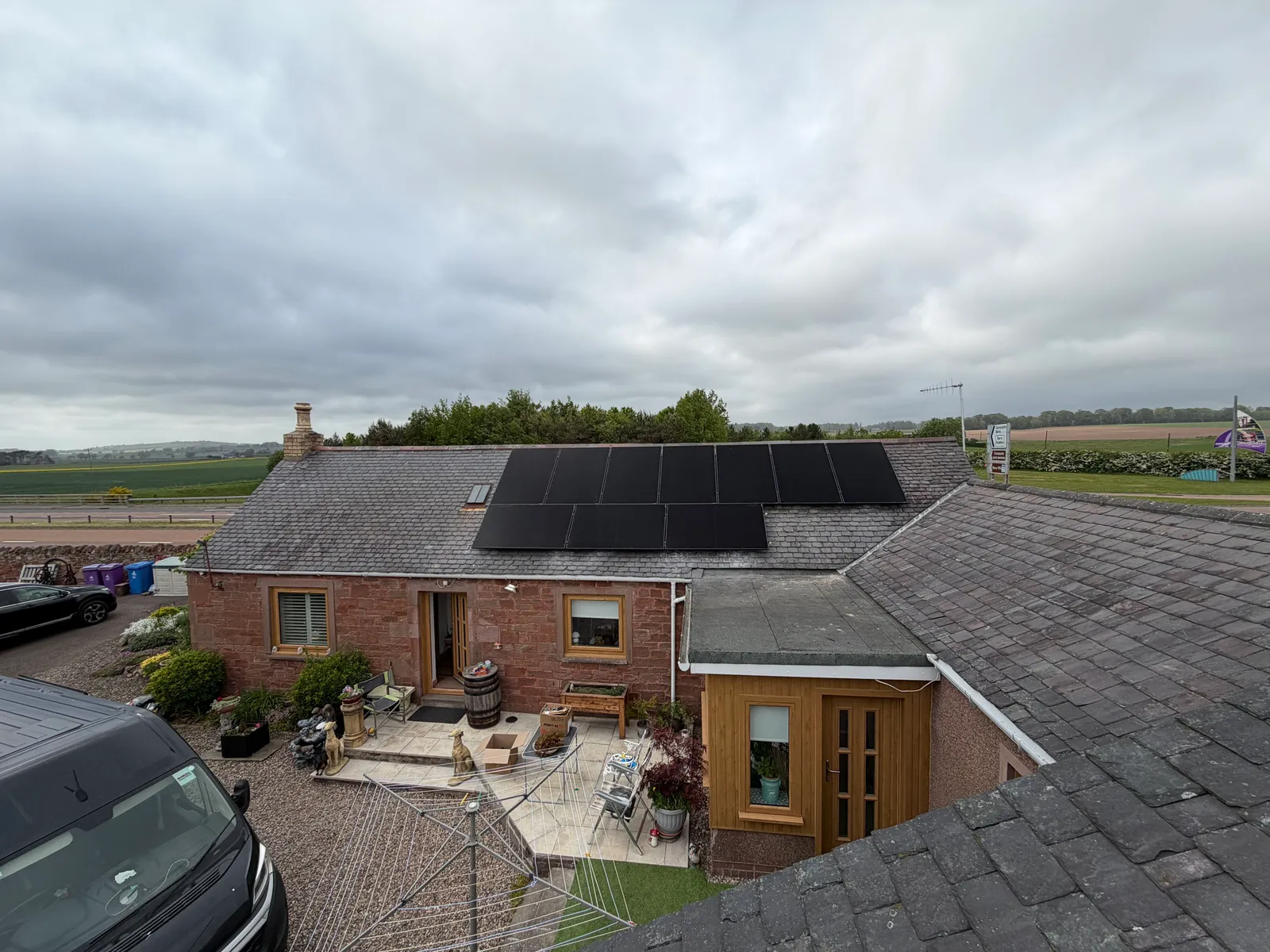 All-black panels on the slate roof of a traditional red sandstone house